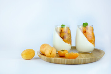 Couple of glasses with some homemade dessert with apricots isolated on white background