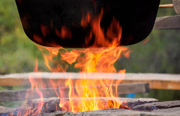 traditional hungarian bogracs goulash soup. cooking dish on open fire in a cauldron. preparing...