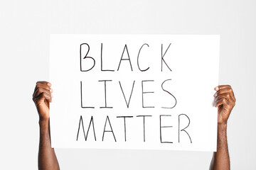 African-American man with poster on white background. Stop racism