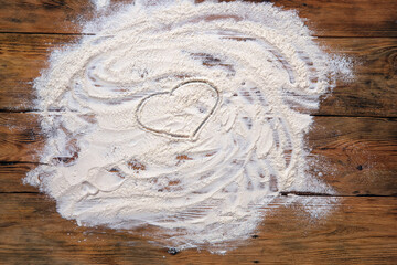 White flour on old rustic wooden table, top view. Baking background with free space for your text.