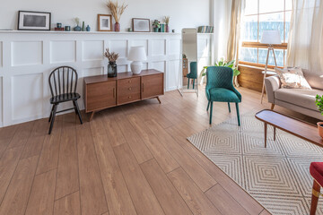 Vintage studio apartment interior in light colors in old style. huge room with large windows with a living room area and a bedroom area. direct sunlight inside.