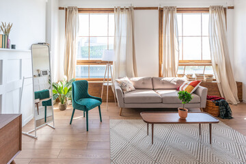 Vintage studio apartment interior in light colors in old style. huge room with large windows with a living room area and a bedroom area. direct sunlight inside.