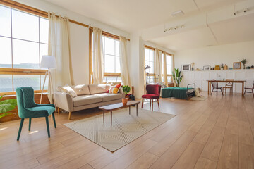 Vintage studio apartment interior in light colors in old style. huge room with large windows with a living room area and a bedroom area. direct sunlight inside.