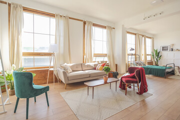 Vintage studio apartment interior in light colors in old style. huge room with large windows with a living room area and a bedroom area. direct sunlight inside.