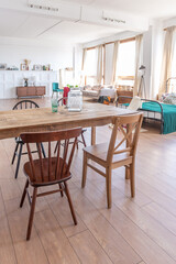 Vintage studio apartment interior in light colors in old style. huge room with large windows with a living room area and a bedroom area. direct sunlight inside.