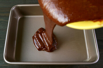 Cake Batter of Flavorful Wholemeal Chocolate Olive Oil Cake Being Poured into Greased Cake Pan