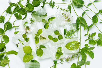 cosmetic ice cubes with chamomile and mint for home care applies to the face. The concept of skin care. cosmetics with herbs on a light background
