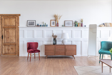 Vintage studio apartment interior in light colors in old style. huge room with large windows with a living room area and a bedroom area. direct sunlight inside.