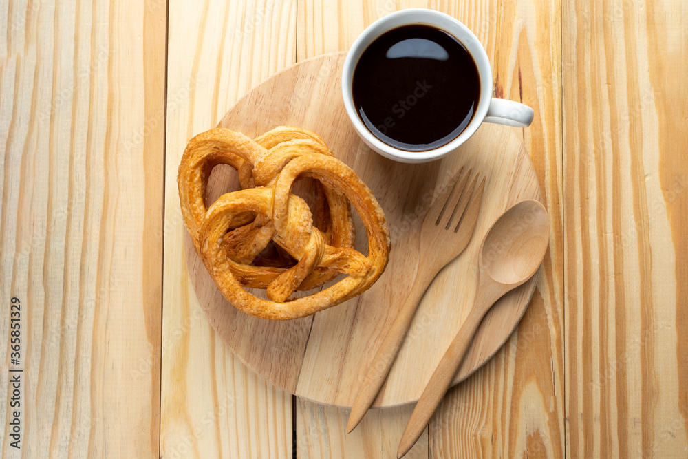 Wall mural pretzels on wood table and black coffee