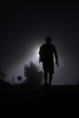 silhouette of a man walking in the night