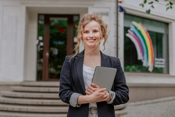 Nice girl standing in the front of business center with tablet in the hands