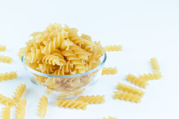 Raw pasta in a cup is isolated.