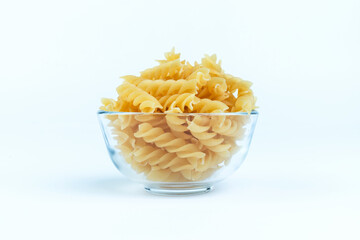 Raw pasta in a cup is isolated.