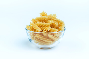 Raw pasta in a cup is isolated.