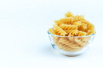 Raw pasta in a cup is isolated.