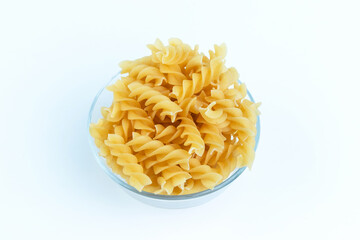 Raw pasta in a cup is isolated.