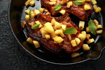 Roasted Pork chops with caramelized apples, walnuts and sage in a cast iron pan
