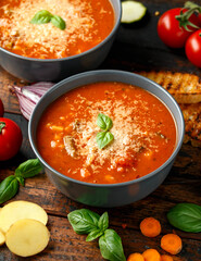 Seasonal vegetables classic minestrone soup with pasta served with cheese, grilled sour dough bread and basil leaves