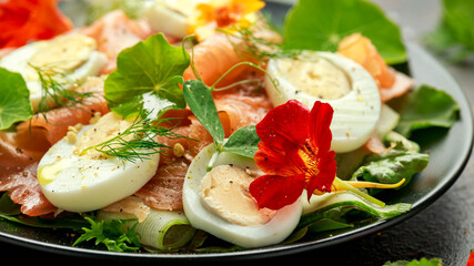 Smoked salmon and cucumber salad with nasturtium leaves and edible flowers. healthy food