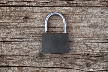 Fototapeta premium the old padlock lies on the wooden surface