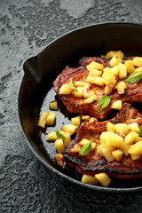 Roasted Pork chops with caramelized apples, walnuts and sage in a cast iron pan