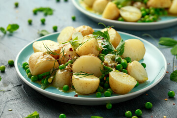 Warm vegetarian new baby potato salad with petit pois peas, Dijon mustard and capers dressing, served with fresh dill