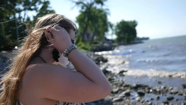 Woman coughs and puts on mask while staring out into the ocean

Coronavirus concept footage in public area during 2020


July 19 2020