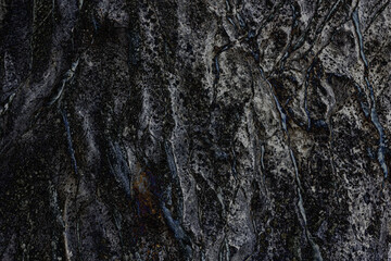 The black texture of natural stone, rock. Close-up of the background texture of a rock or stone. Horizontal orientation