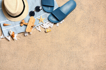 Fototapeta na wymiar Set of beach accessories on sand, top view