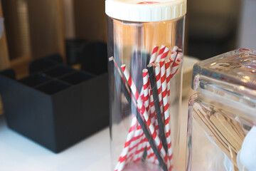 Eco recycling paper straws for drinking in a glass jar at the cafe restaurant, red white and black drinking straws