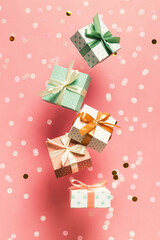 Polka dot pattern gift box with ribbon falling on pink background