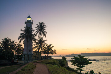 phare blanc entouré de palmier devant une mère superbe au  sud de l'ile du Sri Lanka