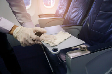 Close up hand is wearing gloves cleaning aircraft seat for covid-19 prevention pandemic