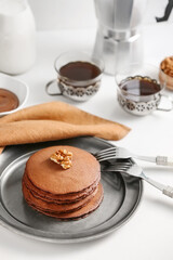 Plate with delicious chocolate pancakes on table
