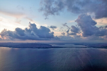 Istanbul and the Bosphorus at sunrise from a height. The deep blue surface of the water is calm.The city is visible in the distance. In the brightening sky there are picturesque pink and purple clouds