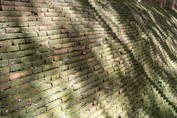 The ancient wall base made of bricks.