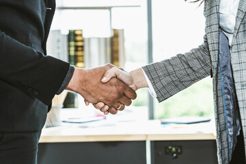 Business people handshake in corporate office showing professional agreement on a financial deal...