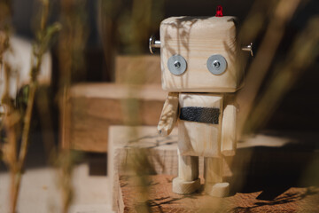 small wooden robot in the wooden jungle. loneliness concept