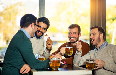 Friends talking and drinking beer in pub