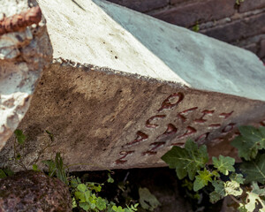 Concrete signpost with Hai Van Pass landmark, that has fallen over. 