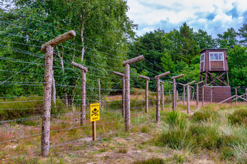 Fototapeta na wymiar barbed wire fence and watchtower at prison camp Frøslev
