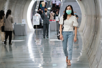 Asian girl wear surgical mask to protect the Covid-19 virus in public areas, New normal lifestyle