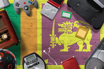 Sri Lanka retro gaming concept. A collection of retro video game controllers shot from above on a national background.
