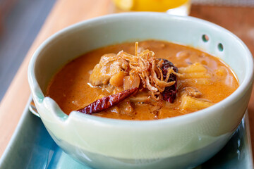 Massaman curry, Chicken Massaman Curry in bowl with vegetables and herbs on the table. Delicious food, yummy curry. Asian food.