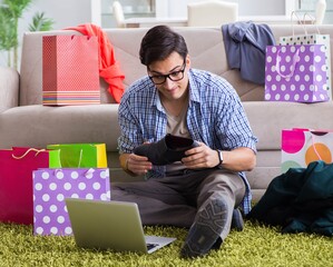 Young man buying clothing online and running blog