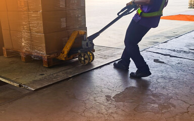 Obraz premium Worker driving forklift loading and unloading shipment carton boxes and goods on wooden pallet from container truck to warehouse cargo storage in logistics and transportation industrial 