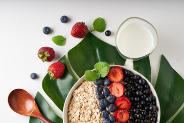 Healthy breakfast, muesli with currants, blueberries and strawberries served in bawl on light backgrund