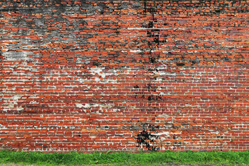 a vintage weathered old manor house old natural red brick garden wall lined with lush green grass perfect for background marketing material as well as wallpaper card poster backdrop