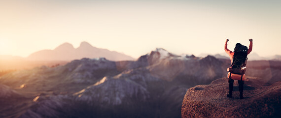Happy man celebrating success on the peak of mountain.