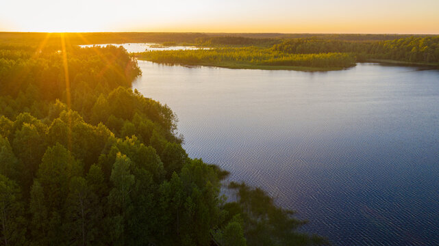 Aerial summer landscape view of a beautiful Jarlepa Lake during a vibrant sunset. Located in Rapla County, Estonia